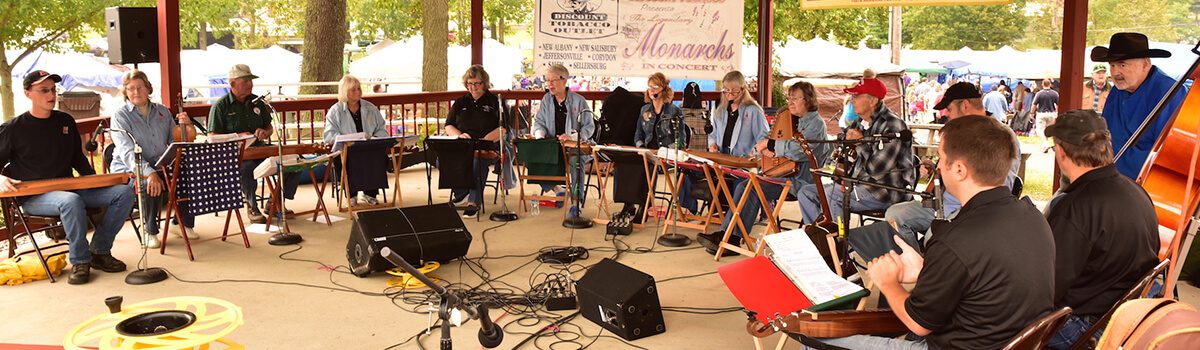 Corydon Dulcimer Society members gathered together outside on a sunny day playing their instruments